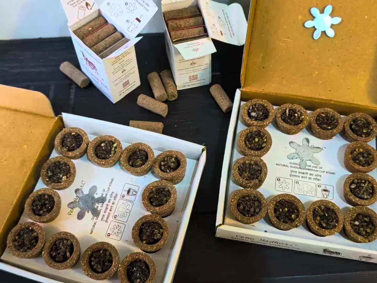 A month's supply laid out — two trays of sambrani cups beside opened packs of dhoop sticks